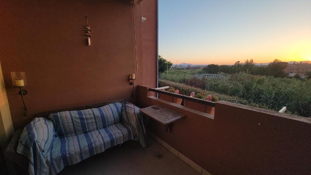 a balcony with a bench and a window with a view at Il Tramonto in Elmas