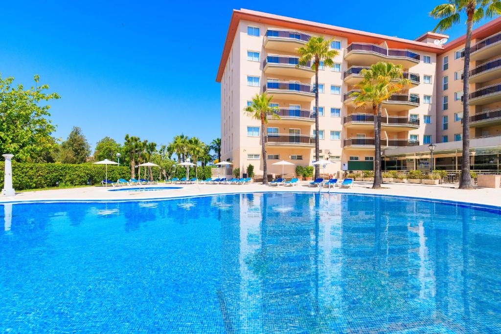 a large swimming pool in front of a building at Rentalmar Pineda Suites in La Pineda
