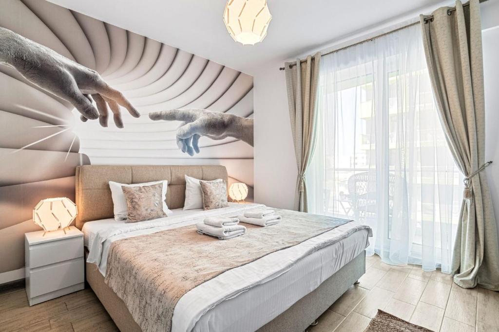 a bedroom with a bed with a painting on the wall at Bavaro 50 by Alezzi Resort in Mamaia Sat/Năvodari