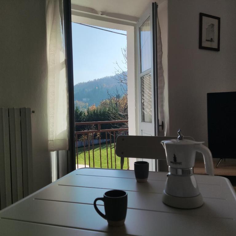 a table with two cups on a table in front of a window at Charme a Corniglio - Suite Cervo in Corniglio