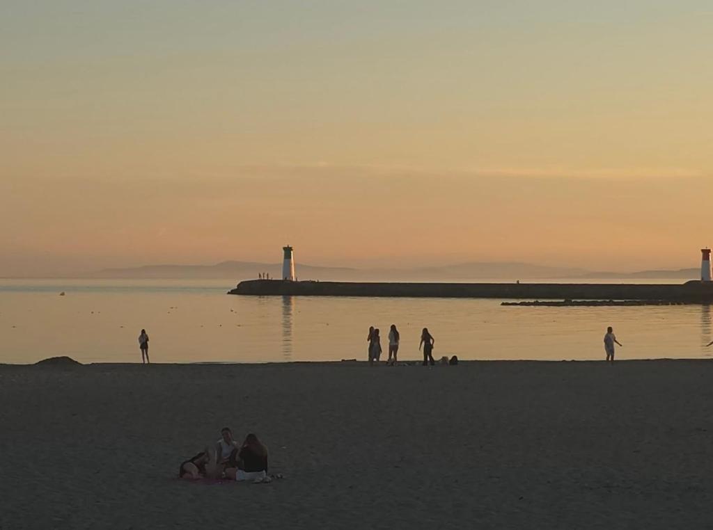 a group of people on the beach at sunset at La Casadrine in Le Grau-dʼAgde
