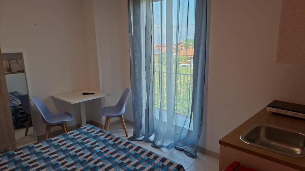 a room with a bed and two chairs and a window at Costadeiapartments in Briatico
