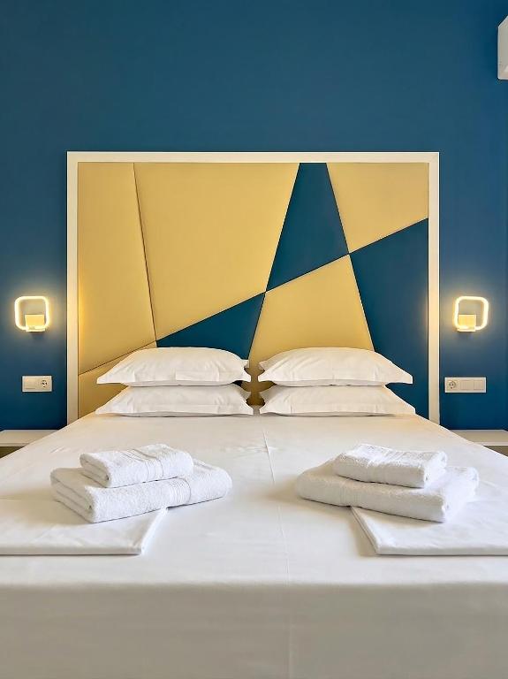 a large bed with two white towels on it at Hotel ADMIRAL POTOS THASSOS in Potos