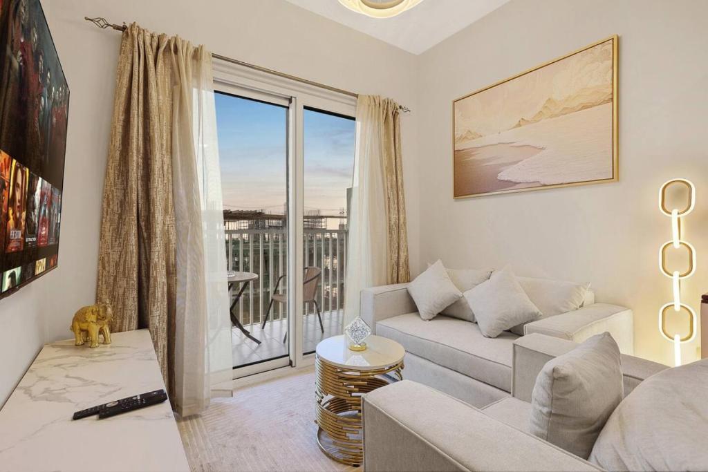 a living room with a couch and a large window at FIRST CLASS 1BR Cozy Luxury Retreat in ‘Ūd al Bayḑāʼ