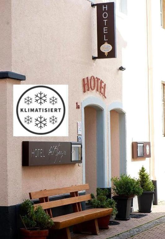 Ein Gebäude mit einem Hotelschild und einer Bank in der Unterkunft Hotel Alt Speyer in Speyer