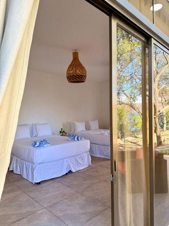 a room with two beds and a glass door at Casa Bambú Hotel in Masaya