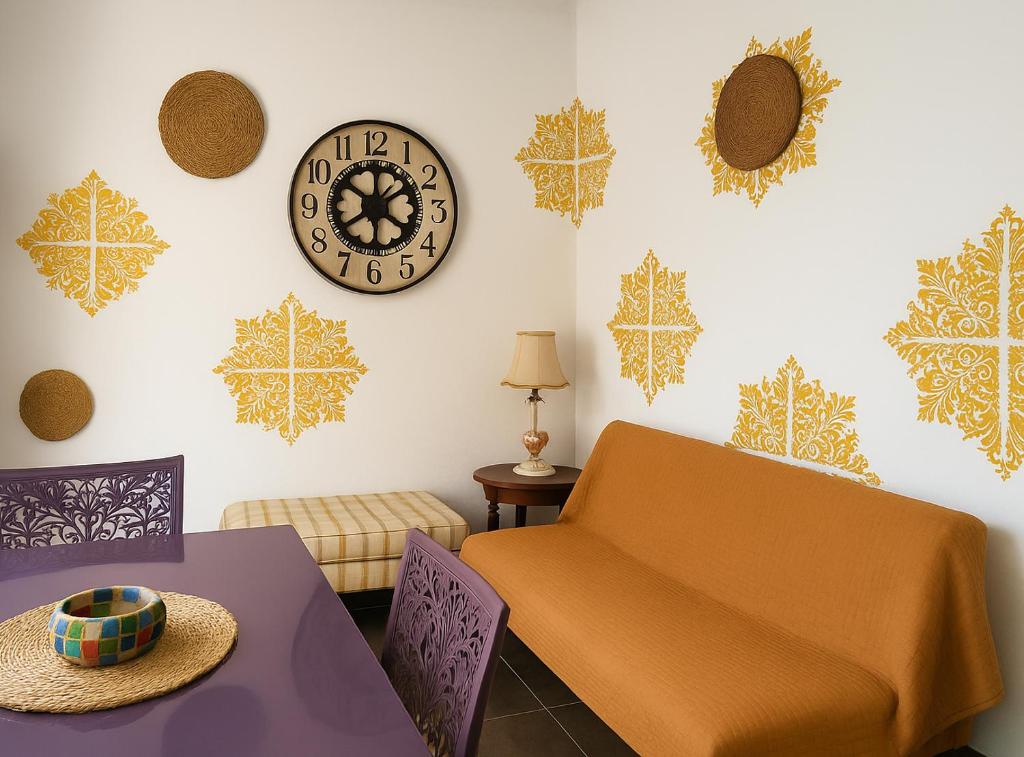a living room with a couch and a clock on the wall at art apartament cerea in Cerea