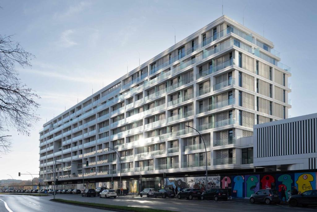 a large white building with cars parked in front of it at Locke at East Side Gallery in Berlin