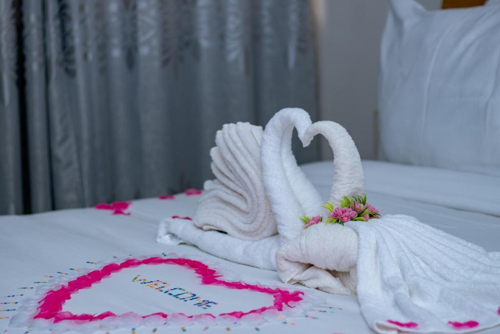 two swans made out of towels on a bed at Kipress Lodge Hôtel in Ouagadougou