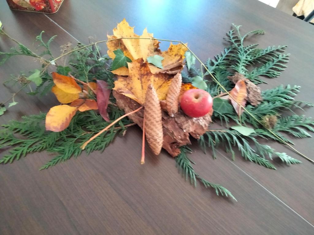 a table topped with a wreath of leaves and fruit at Au petit Mittlach in Mittlach