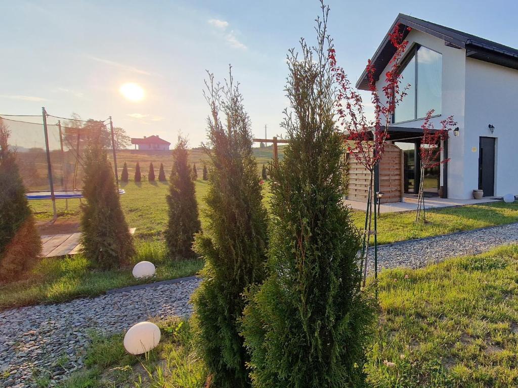 a house with trees in front of a building at Italian House Bieszczady in Bachlowa