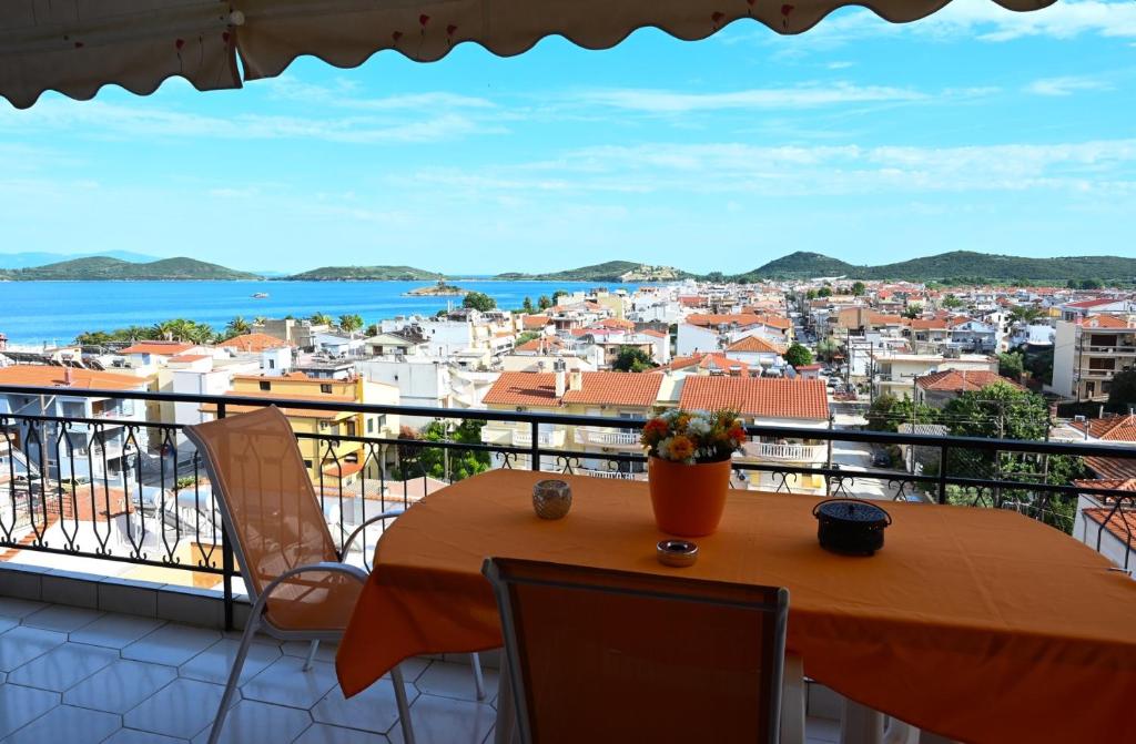 a table and chairs on a balcony with a view at Thalia Sea View Apartment in Nea Peramos
