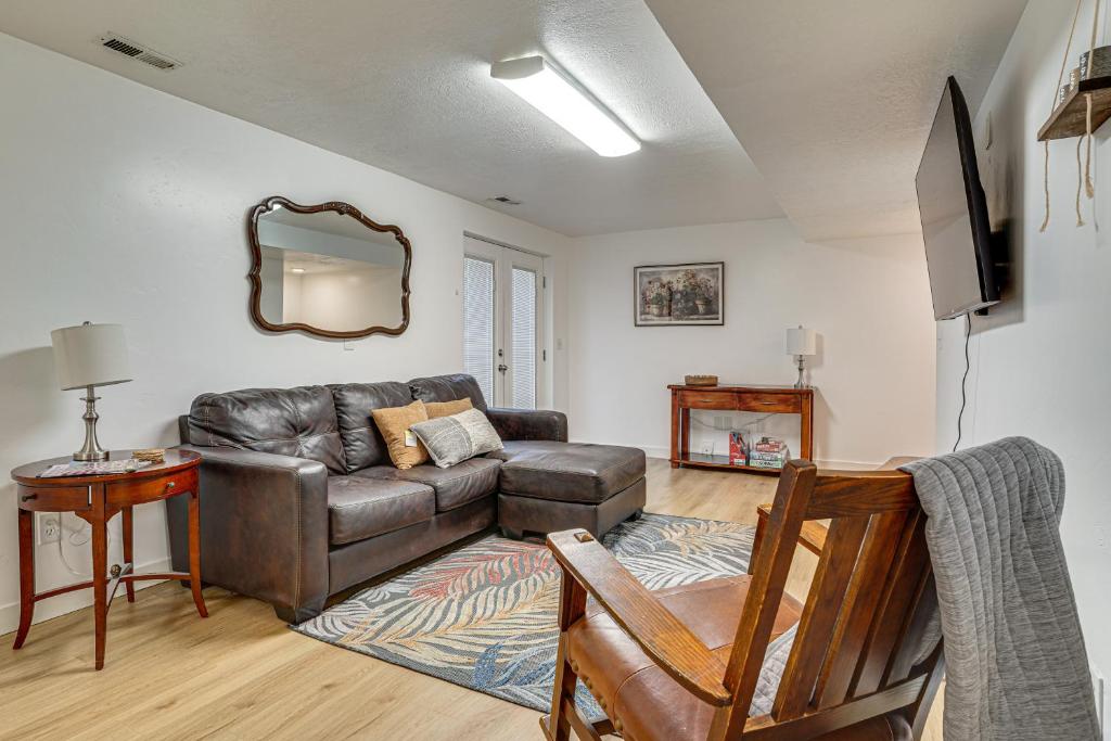 a living room with a leather couch and a mirror at Utah Valley Basecamp: Apt for Hikers & Explorers! in Spanish Fork