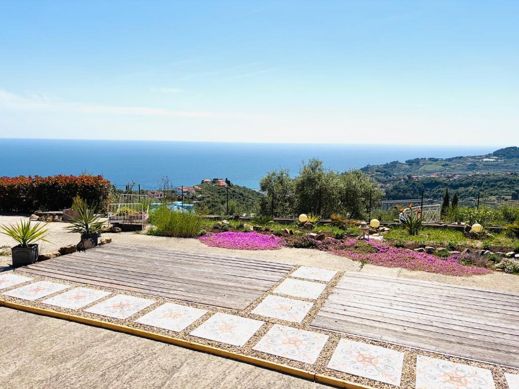 a view of a garden with the ocean in the background at Bella Vista Poggi 180Grad fantastischer Meerblick & Pool in Poggi