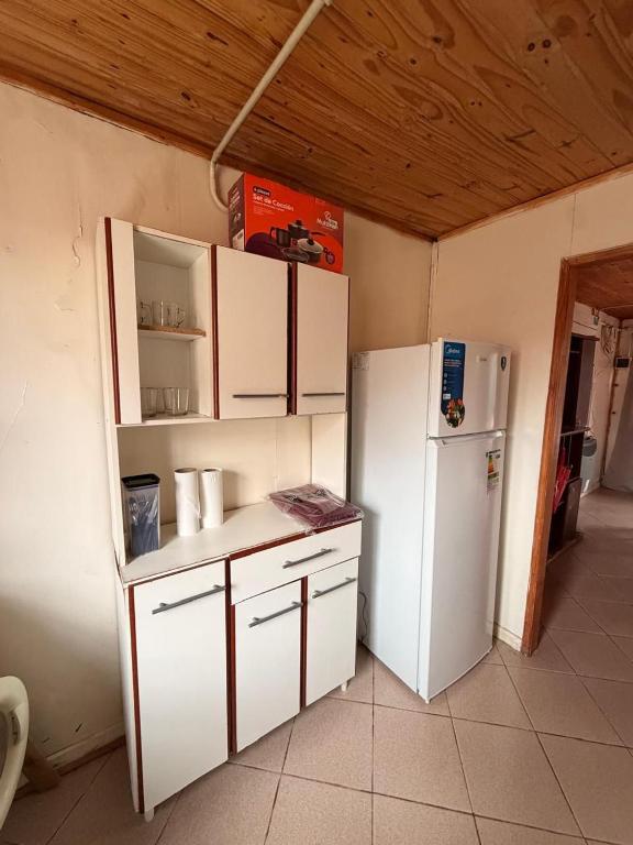 a kitchen with white cabinets and a refrigerator at Servicios Alvarez in Rincon de los Sauces