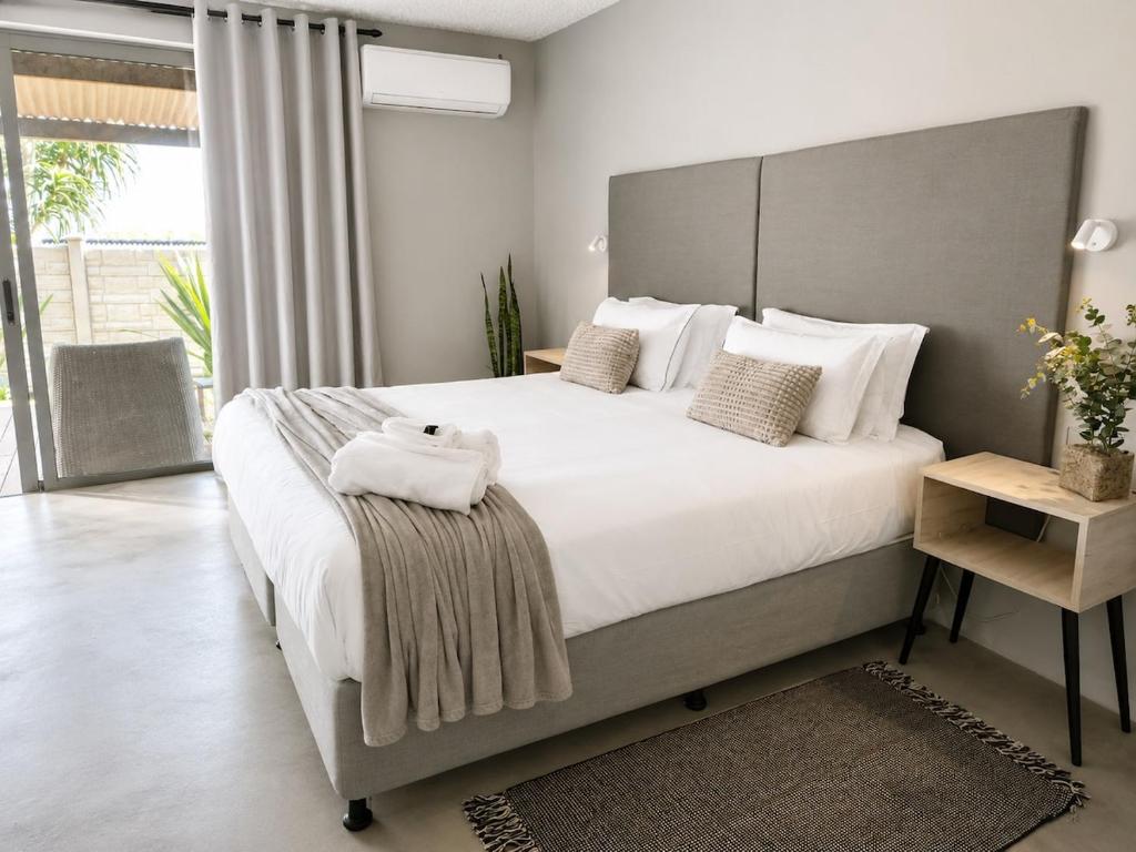 a bedroom with a large bed with white sheets and pillows at Camperdown Stay in Camperdown