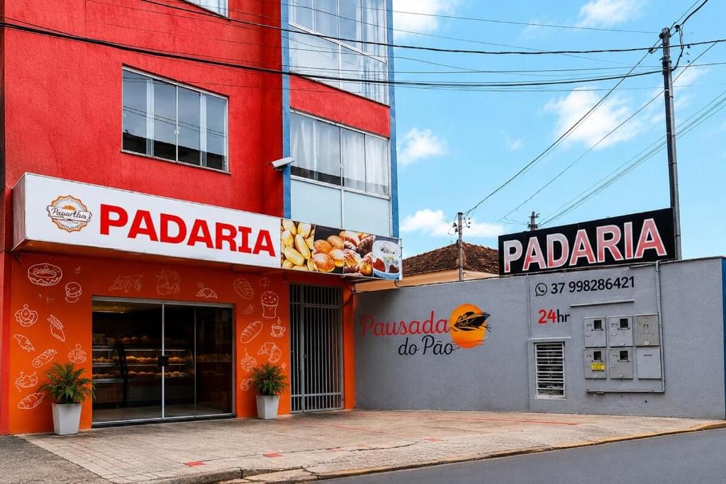 a red building with signs on the side of it at Pousada Lagus Pan in Capitólio