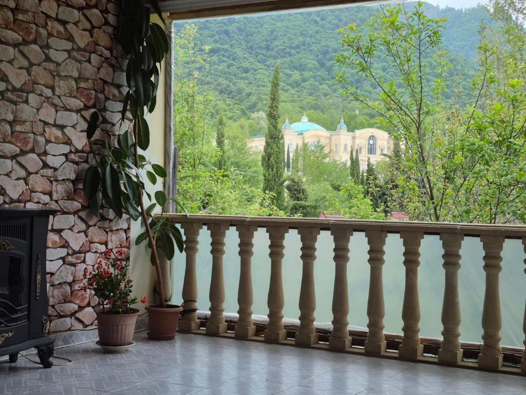 a balcony with a fireplace and a view of a house at Panoramic apartment in Gabala