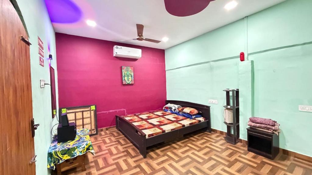 a bedroom with a bed and a pink wall at Gravity Groups Core - La Maison Villa in Pondicherry