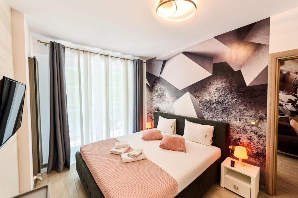 ein Schlafzimmer mit einem Bett und einer Wand mit geometrischen Formen in der Unterkunft Bavaro 28 by Alezzi Resort in Mamaia Nord – Năvodari