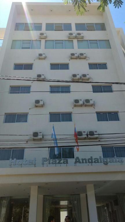 a building with two flags in front of it at Hotel Plaza Andalgala in Andalgalá