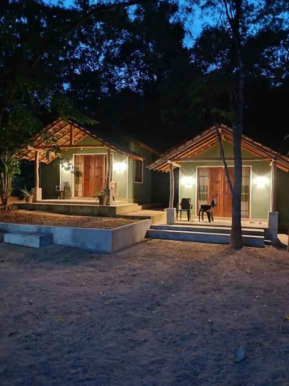 a house at night with a dog sitting in front of it at Green Senz - Tourist Board Approved Hotel & Hostel - Sigiriya in Sigiriya