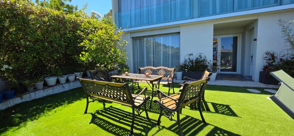 a patio with a table and chairs on a lawn at Villa HARMONY in Vallauris