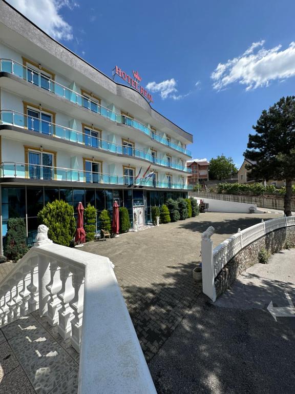 a hotel with a white fence in front of it at Hotel Restaurant Real in Kolgecaj