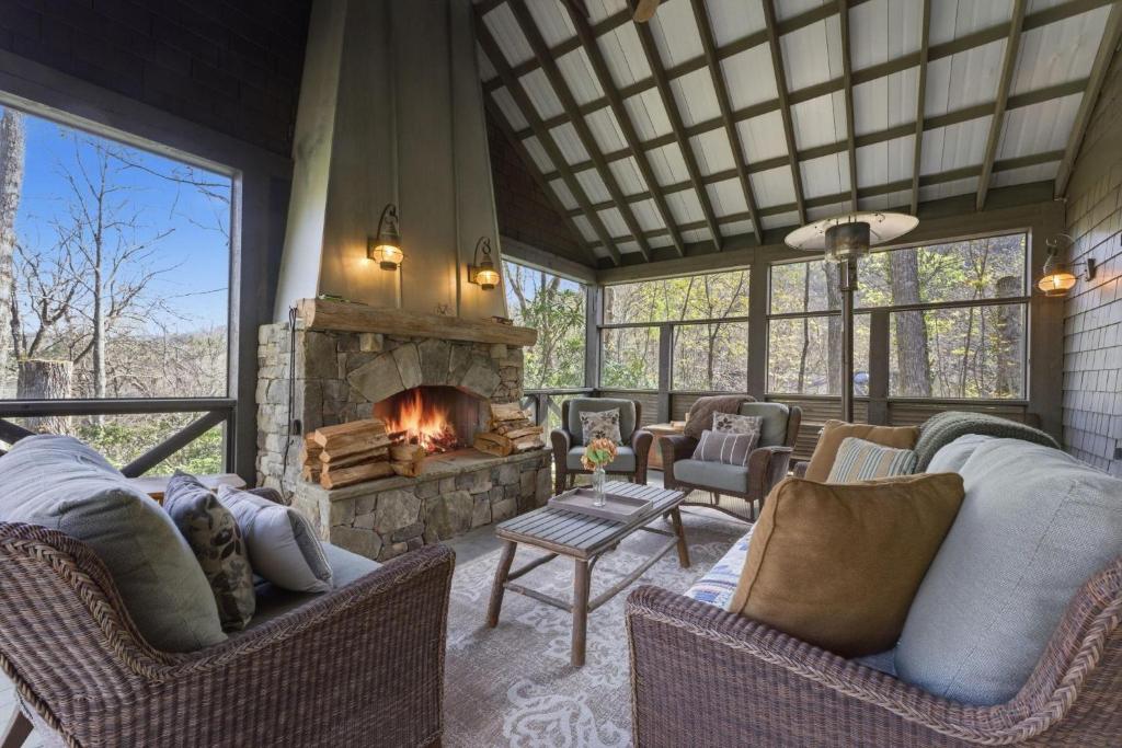 a living room with couches and a stone fireplace at Sunset Nest in Highlands