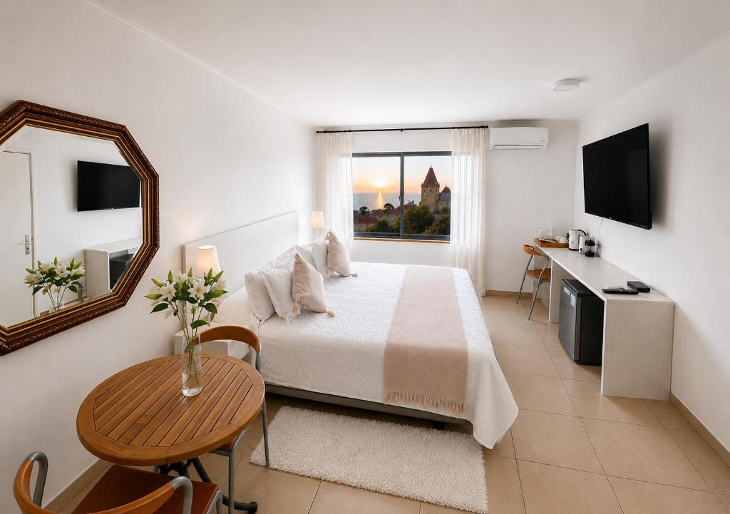 a bedroom with a bed and a table and a mirror at Hotel Carande, Papudo in Papudo