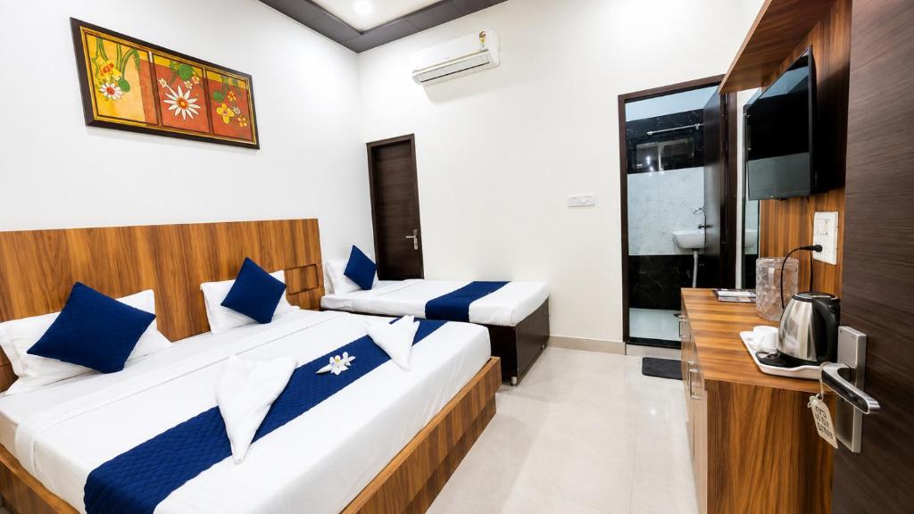 a room with two beds and a television in it at Hotel RK Residency Near,Prem mandir,Keli kunj & Bankey bihari Budget hotel in vrindavan in Vrindāvan