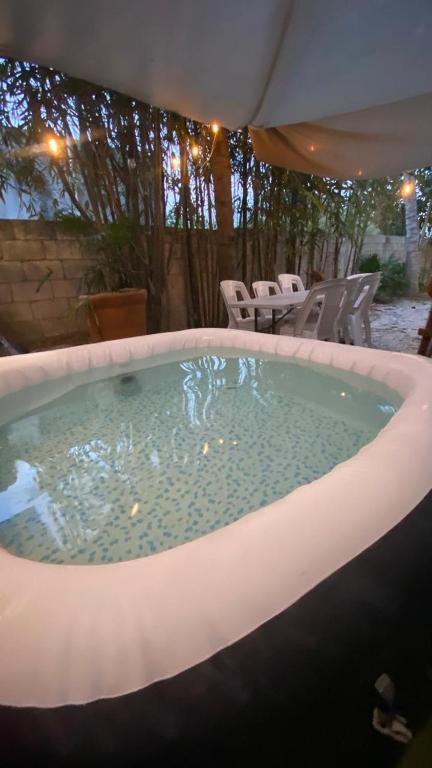 ein großer Whirlpool im Garten mit Stühlen in der Unterkunft Corazón Abierto in Chicxulub
