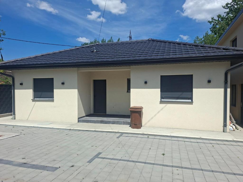 a white house with two windows and a driveway at Apartmani Jet Set in Bor