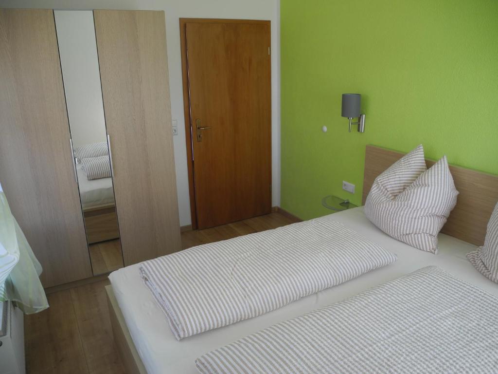 Cama blanca en habitación con paredes verdes en Ferienwohnung Wünsche en Weißensberg