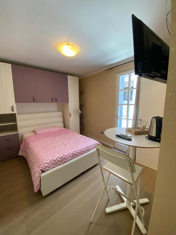 a bedroom with a bed and a desk with a computer at AFFITTACAMERE PIAZZA UNITA' in Monfalcone
