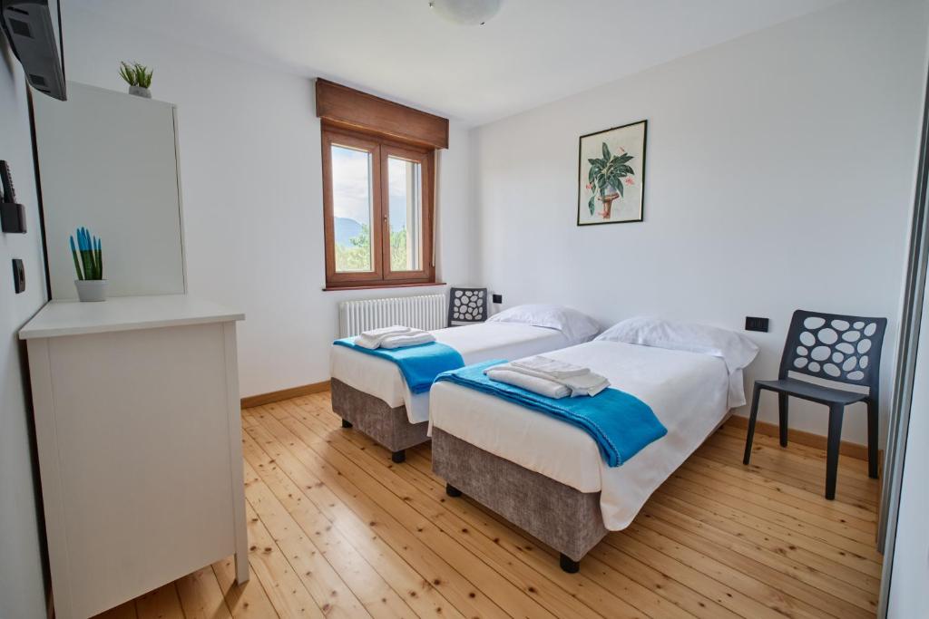 a bedroom with two beds and a window at Meridiana Gemona in Taboga