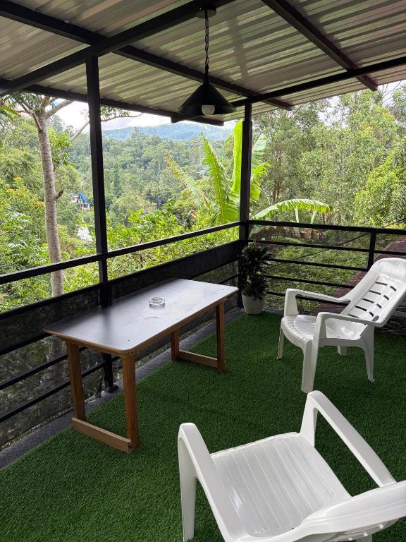 a table and two chairs on a porch with a view at Hill Nest Ella in Bandarawela