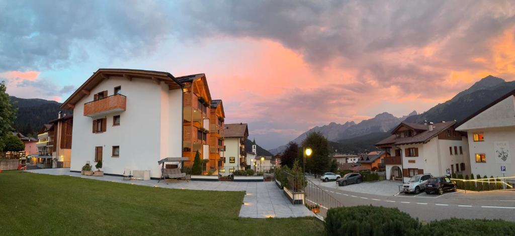 a group of buildings in a town with a sunset at Residence Cima Tosa in Andalo