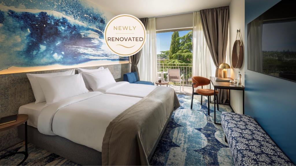 a hotel room with a bed and a desk at Remisens Hotel LUCIJA in Portorož