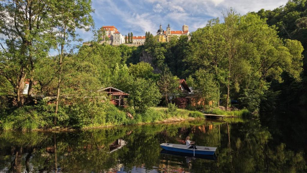 a boat on a river with a castle in the background at Chata V Podzámčí in Vranov nad Dyjí