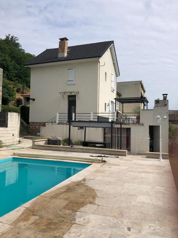 a house with a swimming pool in front of it at Villa avec Piscine in Brive-la-Gaillarde
