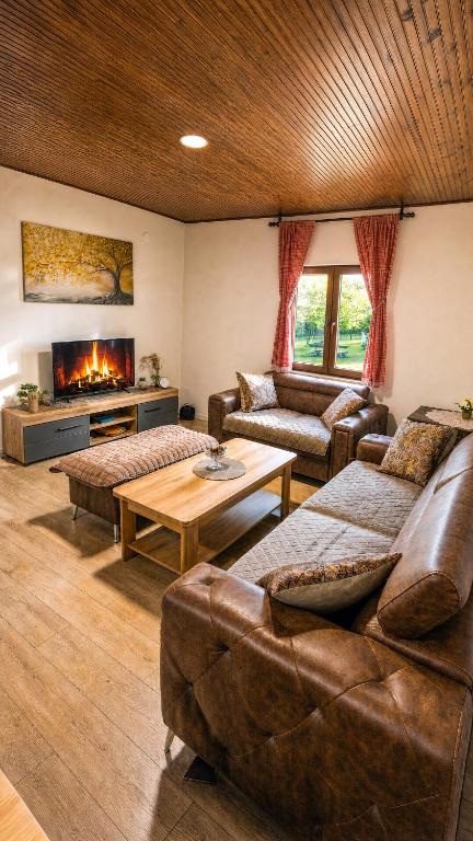 a living room with leather furniture and a fireplace at River Valley Guest House in Foča
