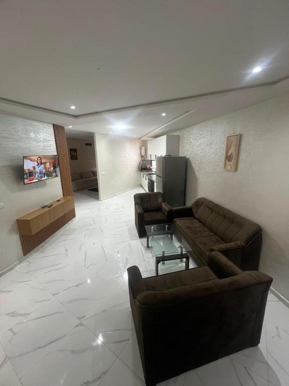 a living room with two leather couches and a table at best standing with ascenceur in El Jadida