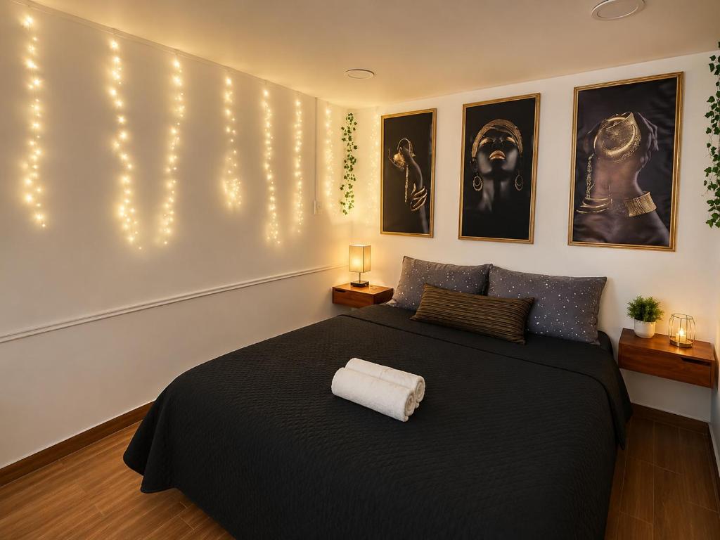 a bedroom with a black bed with lights on the wall at Yui Loft cómodo para pareja o estancia tranquila in Pachuca de Soto
