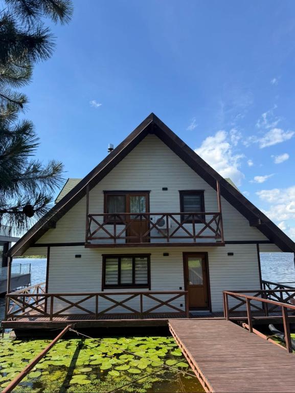 a white house with a dock in front of it at Zoloche Chalet in Vishenki