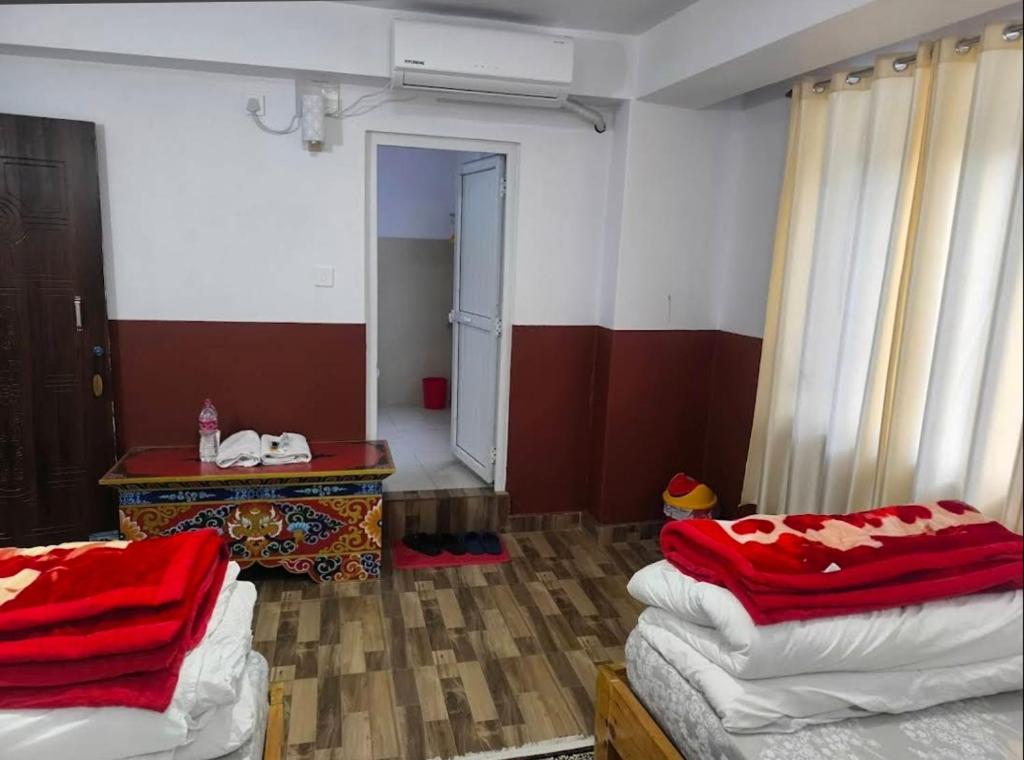 a room with two beds and a table in it at Marpha appleland hotel and suite in Tukucha