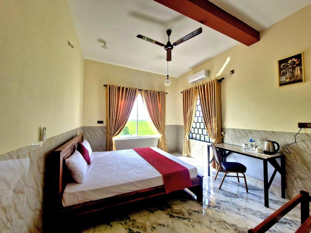 a bedroom with a bed and a desk and a table at Town Tulip in Karativu