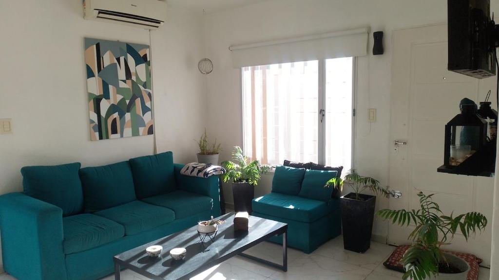 a living room with a blue couch and a table at Marce's house in General Roca