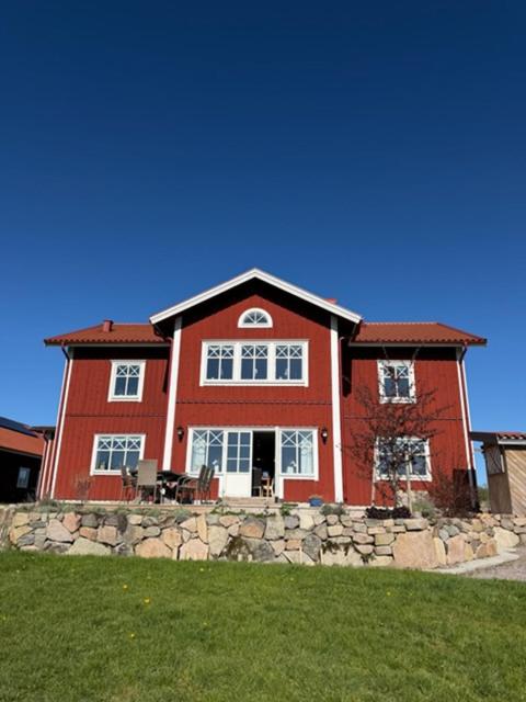 a large red brick house with a stone wall at Naturskönt boende nära sjö in Ör