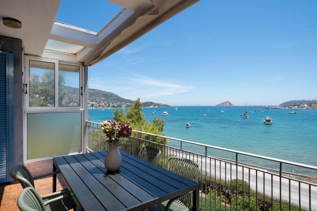 a balcony with a table and a view of the water at KYMA by A&D Properties in Porto Rafti